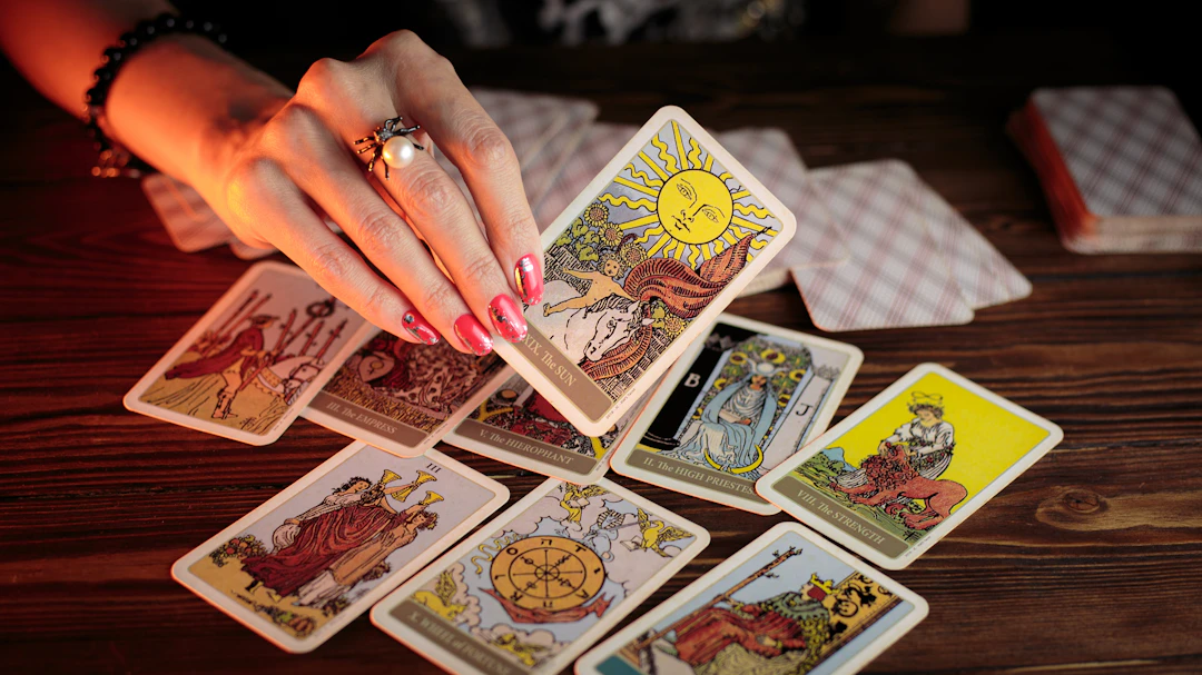Carta de tarot sostenida sobre un fondo oscuro para ilustrar las diferencias entre tarot y oráculo